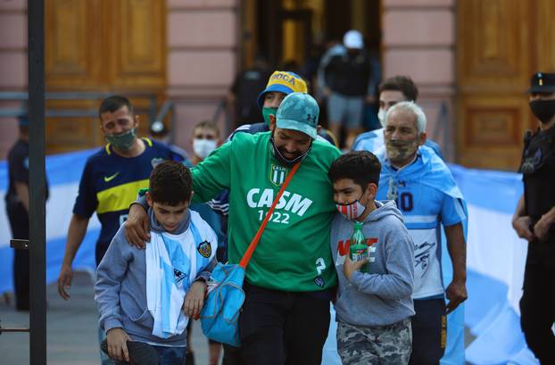 People react as they leave the presidential palace Casa Rosada after seeing the casket of soccer legend Diego Maradona, in Buenos Aires