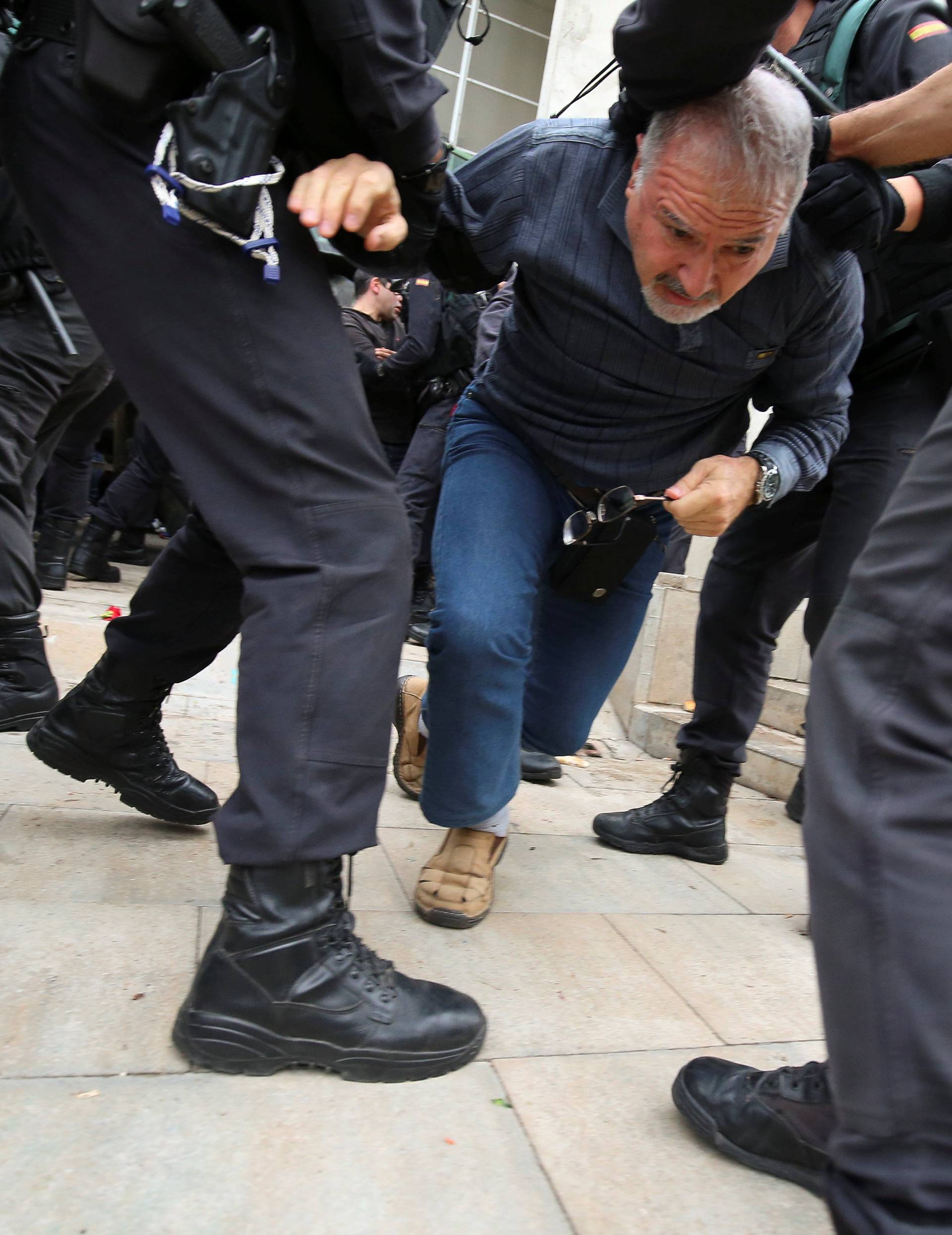 Man is dragged away by officers outside polling station for Catalonia referendum in Sant Julia de Ramis