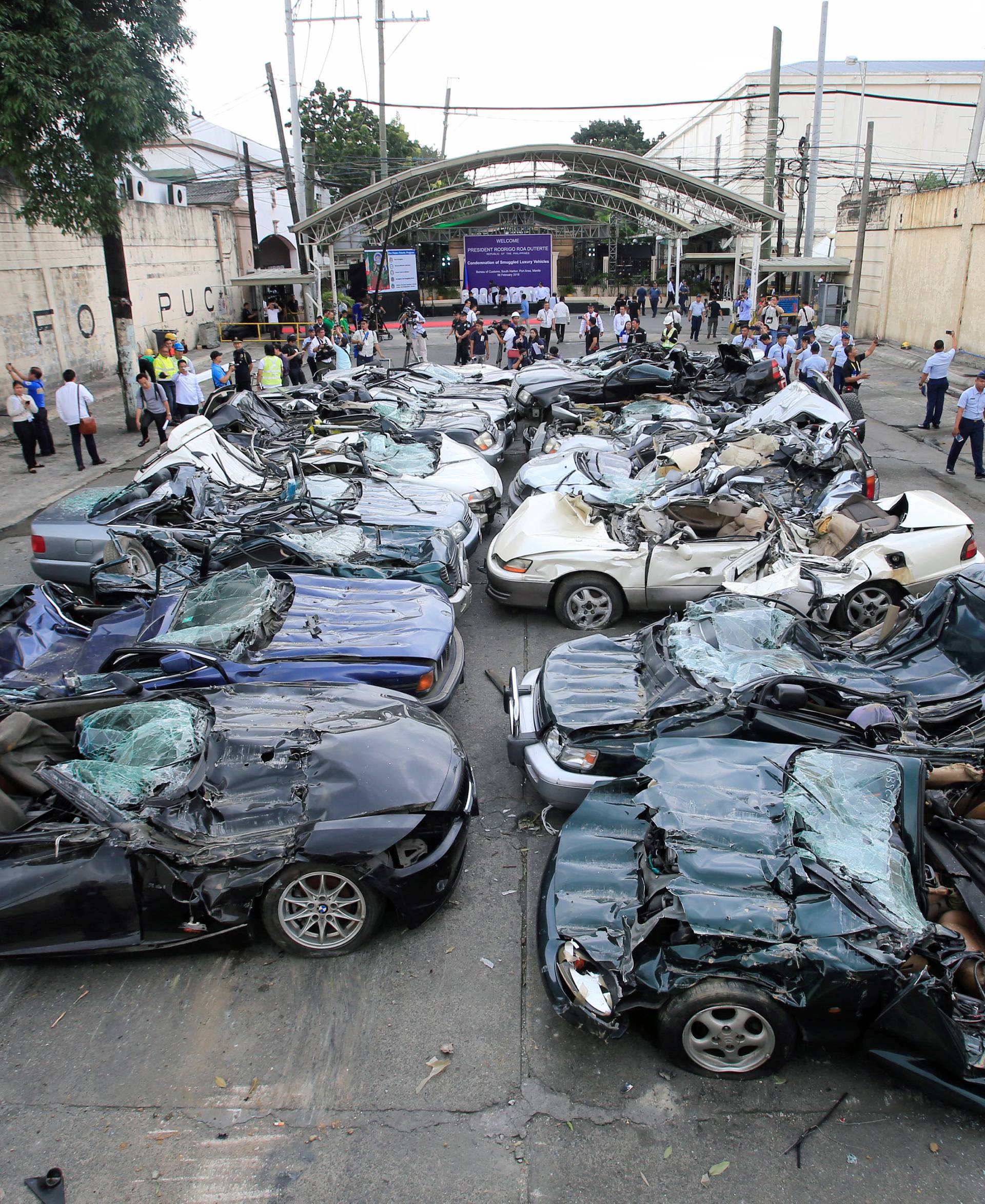 A bulldozer destroys condemned smuggled luxury cars worth 61,626,000.00 pesos during the 116th Bureau of Customs founding anniversary in Manila