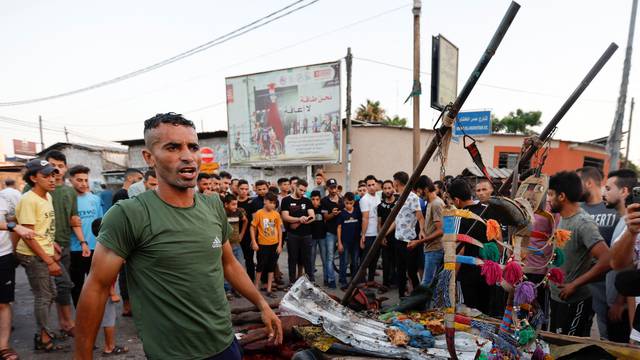 Palestinians inspect the damage, amid Israel-Gaza fighting