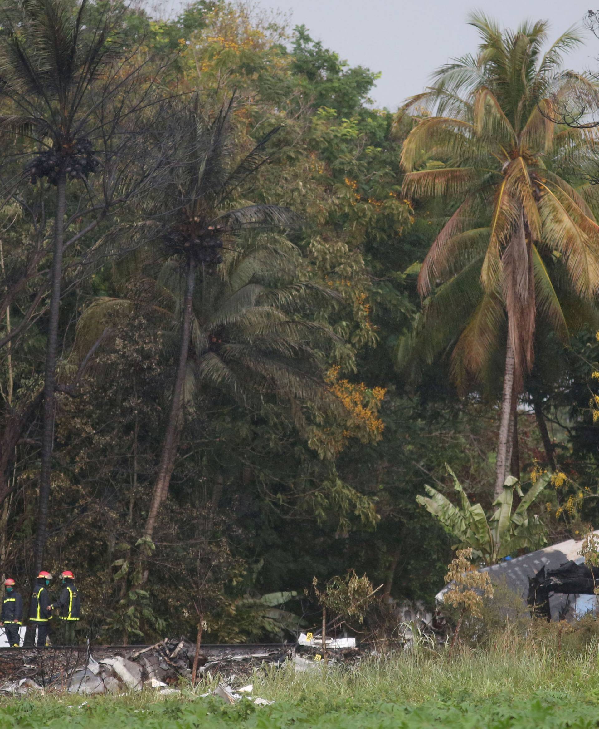 Firefighters work at the wreckage site of a Boeing 737 plane that crashed in the agricultural area of Boyeros