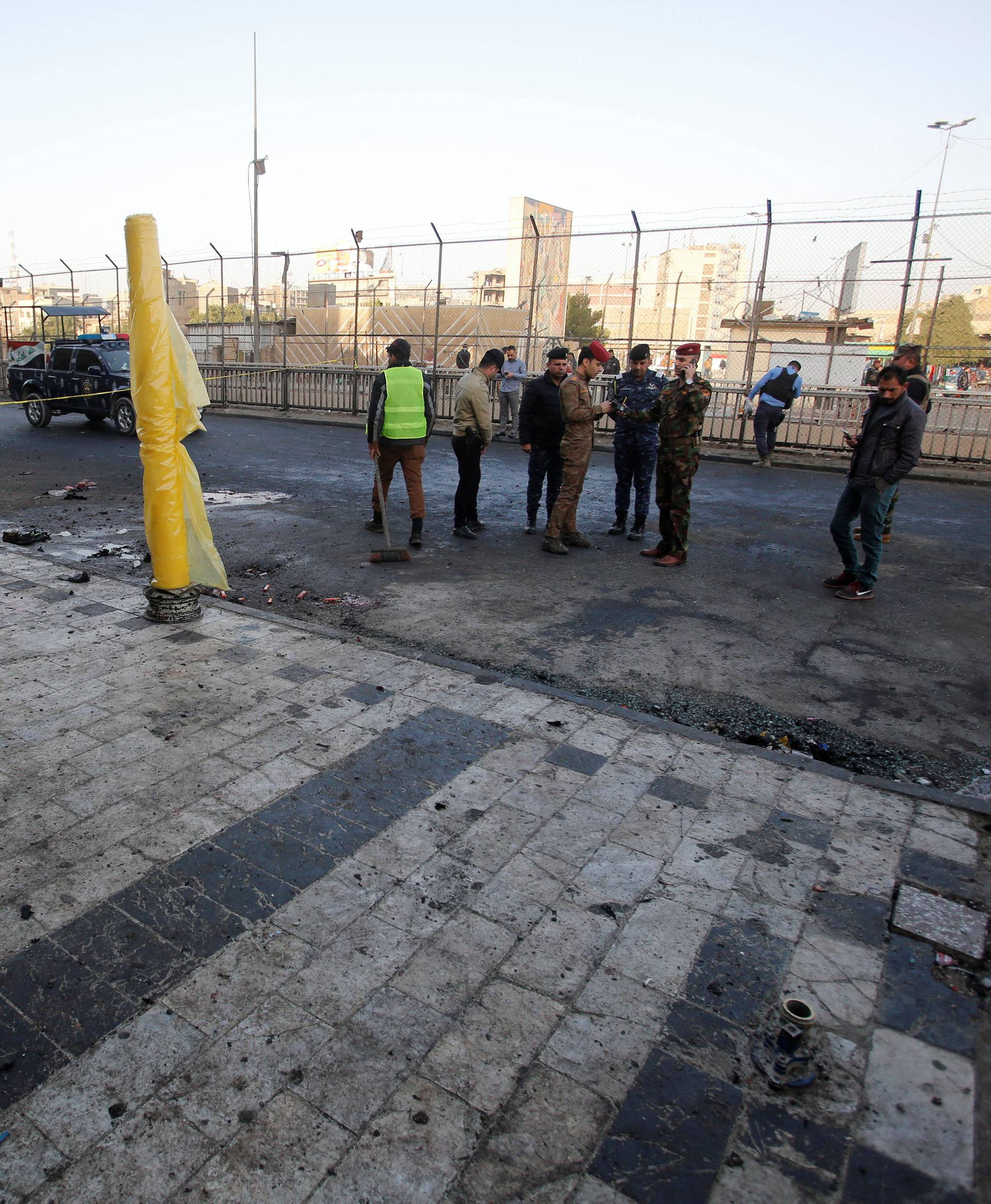 Iraqi security forces inspect the site of a bomb attack in Baghdad