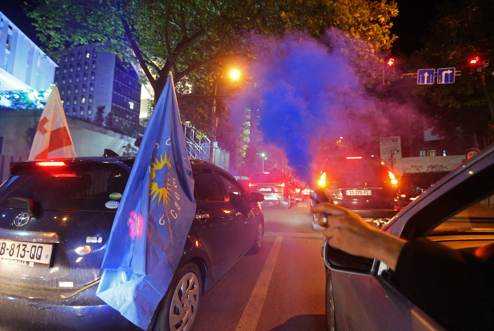 Supporters of the Georgian Dream party celebrate after the announcement of exit poll results in Tbilisi