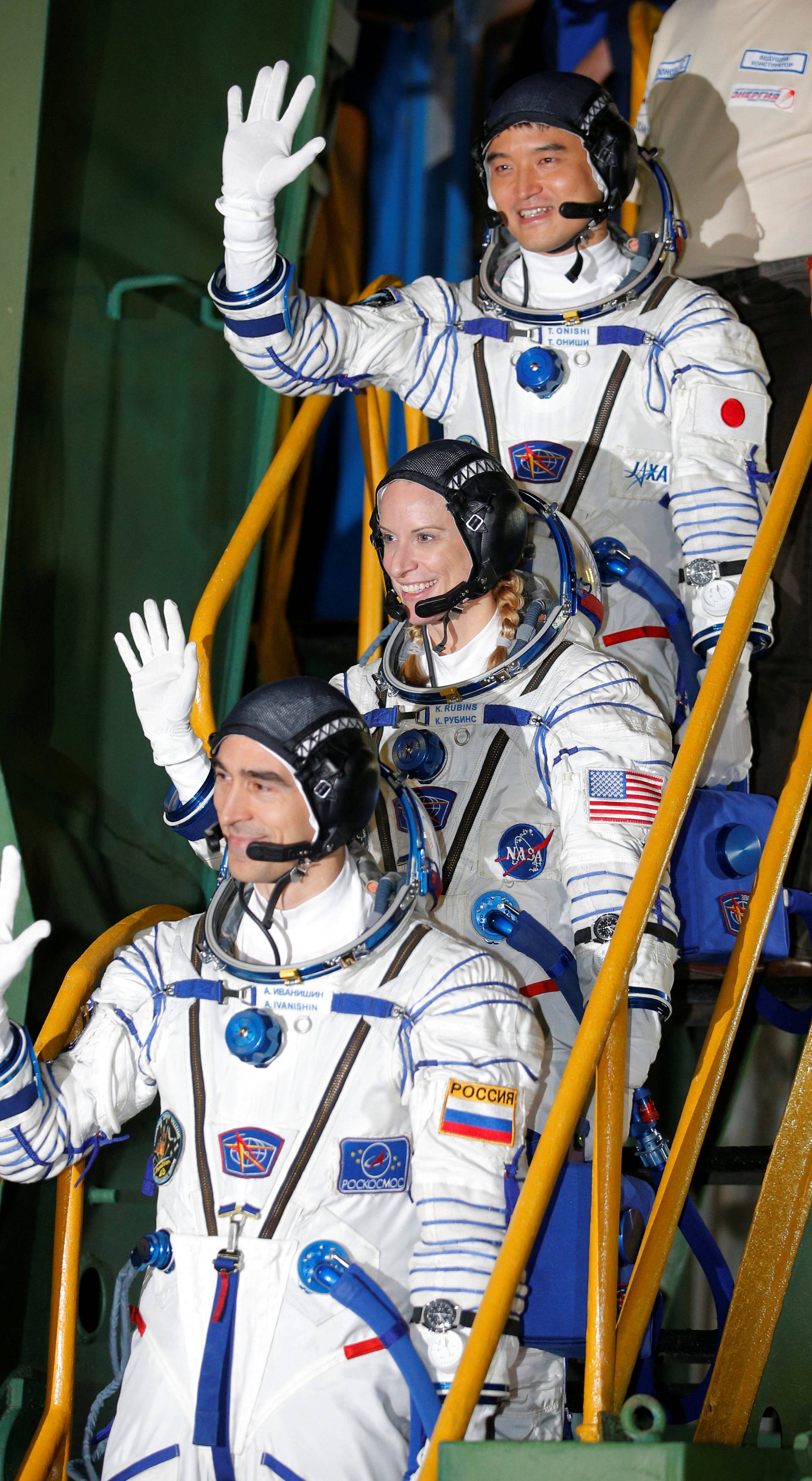 The International Space Station (ISS) crew members Kate Rubins of the U.S., Anatoly Ivanishin of Russia and Takuya Onishi of Japan gesture close to the rocket prior the launch at the Baikonur cosmodrome, Kazakhstan