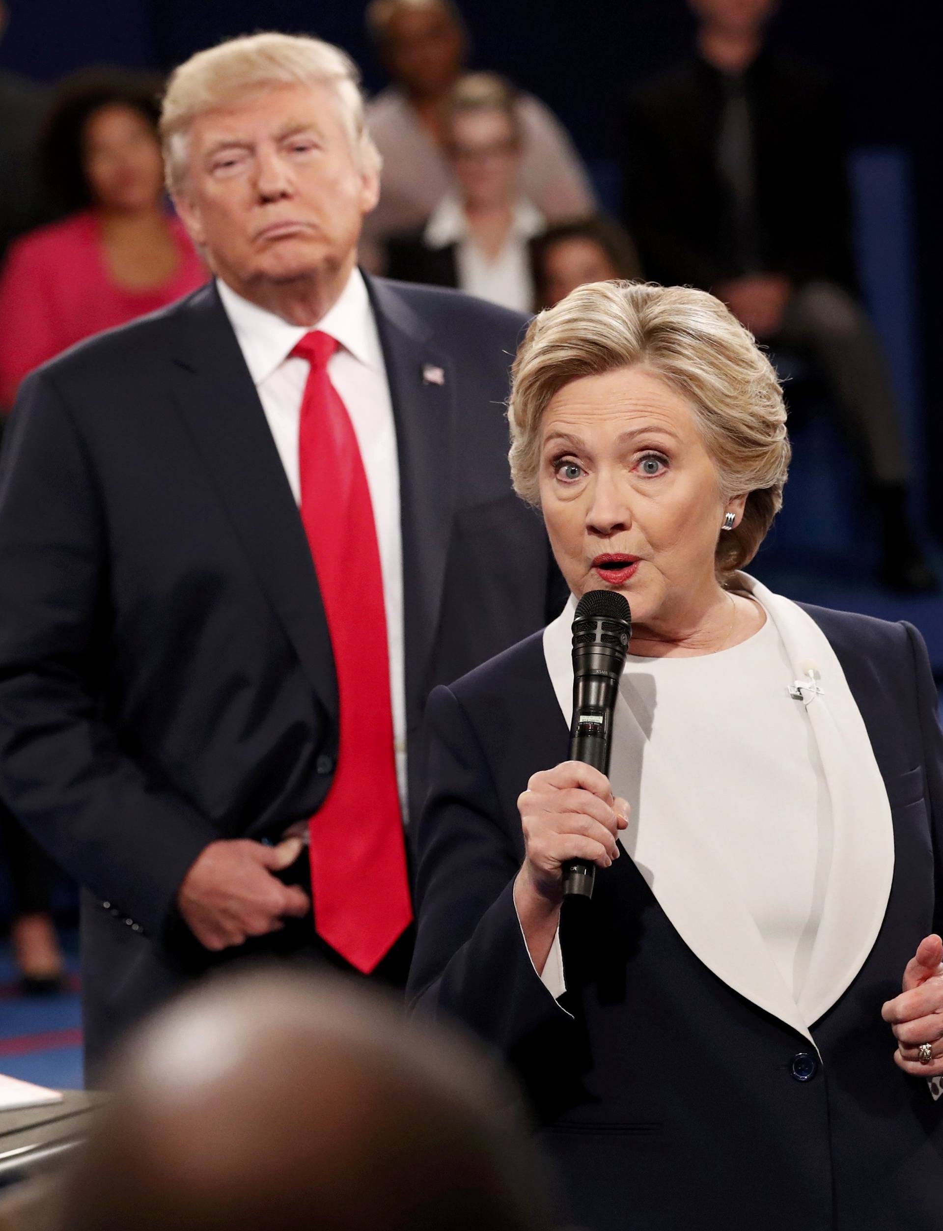 Republican U.S. presidential nominee Trump listens as Democratic nominee Clinton answers a question from the audience during their presidential town hall debate in St. Louis