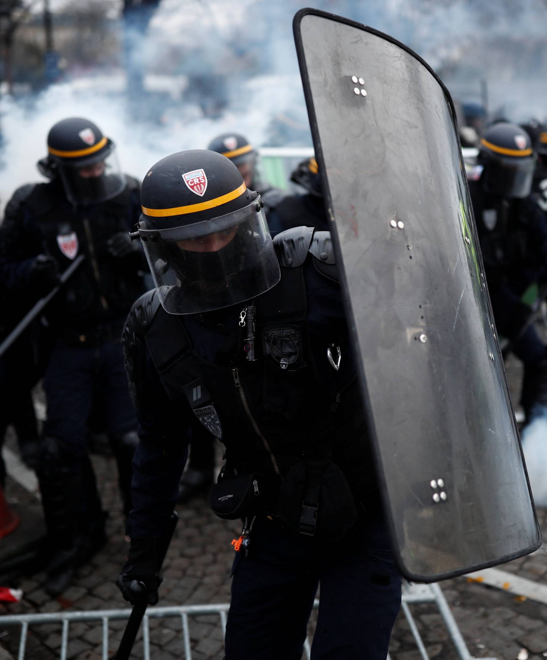 Protesters wearing yellow vest, a symbol of a French drivers' protest against higher fuel prices, clash with riot police on the the Champs-Elysee in Paris