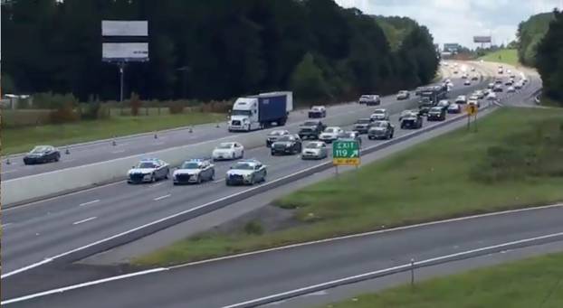 South Carolina Highway Patrol cars escort a line of vehicles as they lead traffic from Charleston to Columbia, as residents prepare ahead of Hurricane Florence