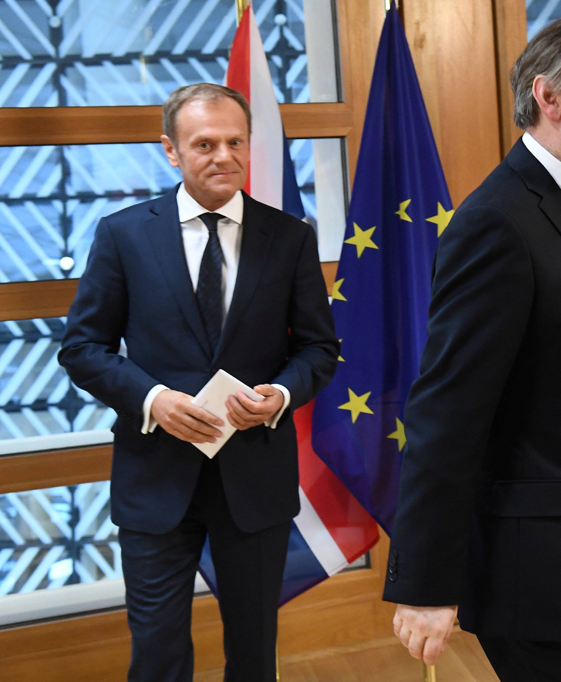 EU Council President Donald Tusk watches Britain's permanent representative to the European Union Tim Barrow leave after he hand delivered British Prime Minister Theresa May's Brexit letter in notice of the UK's intention to leave the bloc in Brussels