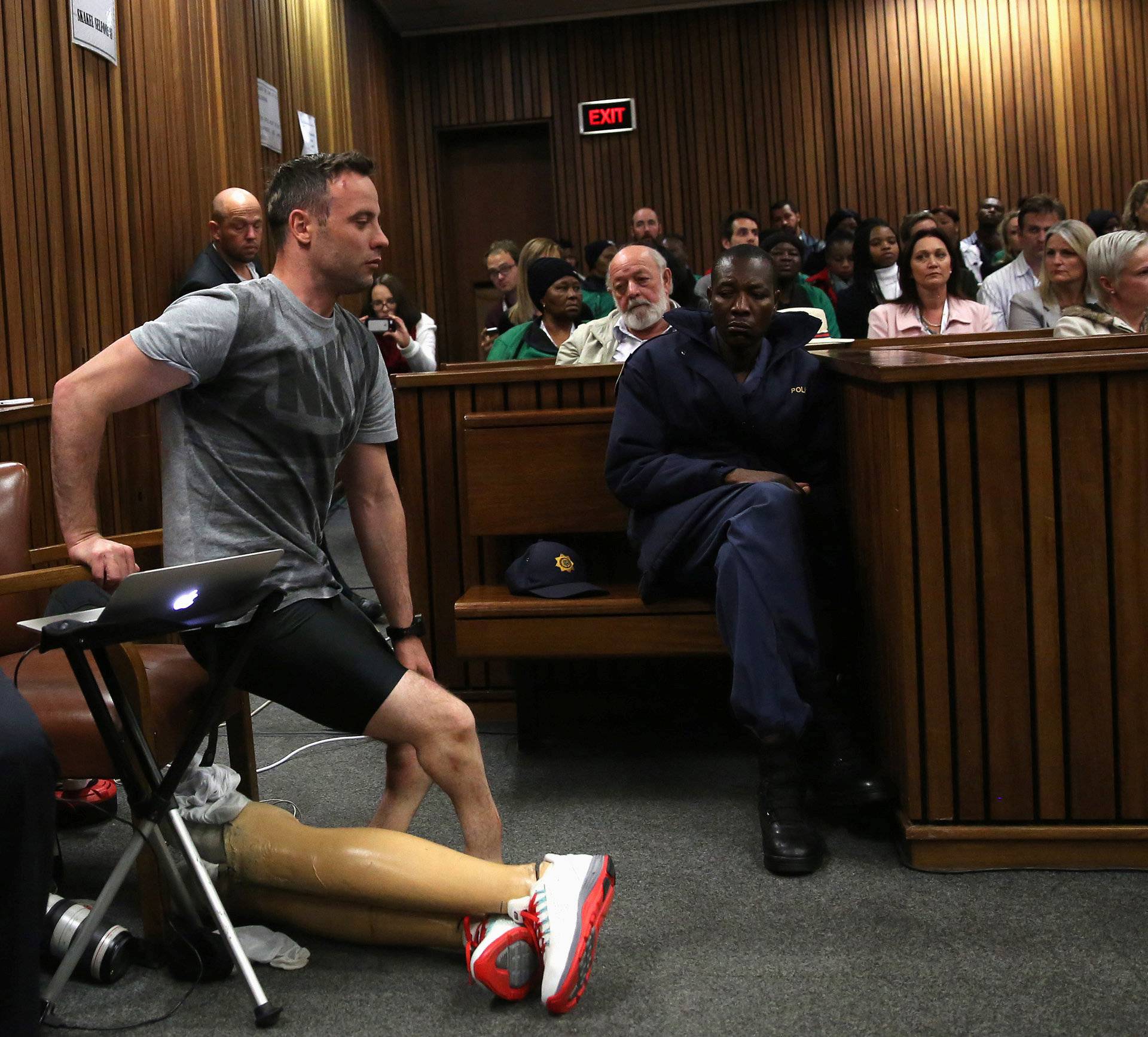 Paralympic gold medalist Oscar Pistorius prepares to walk across the courtroom without his prosthetic legs during the third day of the resentencing hearing for the 2013 murder of his girlfriend Reeva Steenkamp, at Pretoria High Court