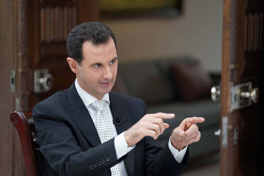 Syria's President Bashar al Assad gestures during an interview with a Greek newspaper in Damascus