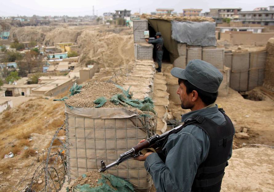 Afghan police officers keep watch at their forward base on the outskirts of Kunduz province