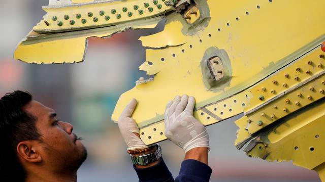 A KNKT official carries debris from the crashed Lion Air flight JT610 at Tanjung Priok port in Jakarta