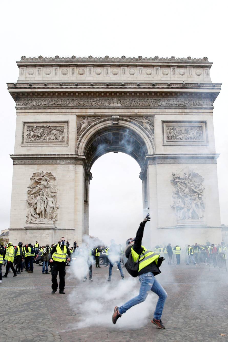 Tear gas floats in the air near the Arc de Triomphe as protesters wearing yellow vests, a symbol of a French drivers' protest against higher diesel taxes, demonstrate in Paris