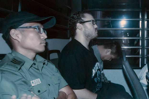 Rurik George Caton Jutting, a British banker charged with two counts of murder after police found the bodies of two women in his apartment, sits in the back row of a prison bus as he arrives at the Eastern Law Courts in Hong Kong, China