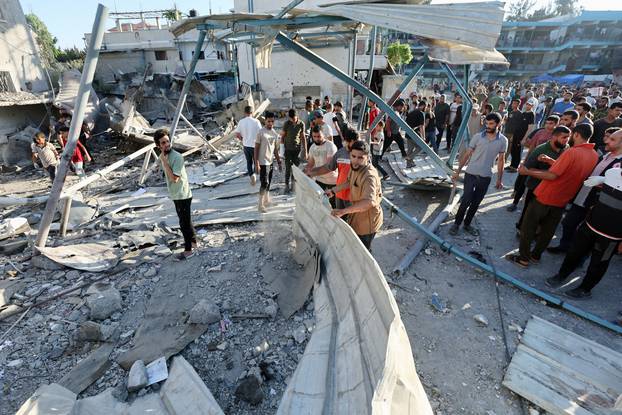 Palestinians react, after an Israeli air strike on a UN school sheltering displaced people, amid the Israel-Hamas conflict, in Nusairat