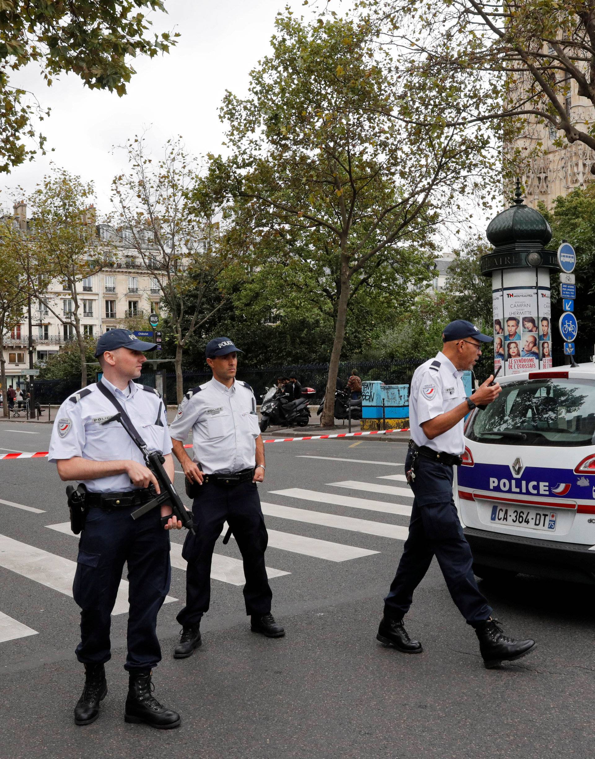 French police secure the area next to a church during a security operation in a shopping district of Paris
