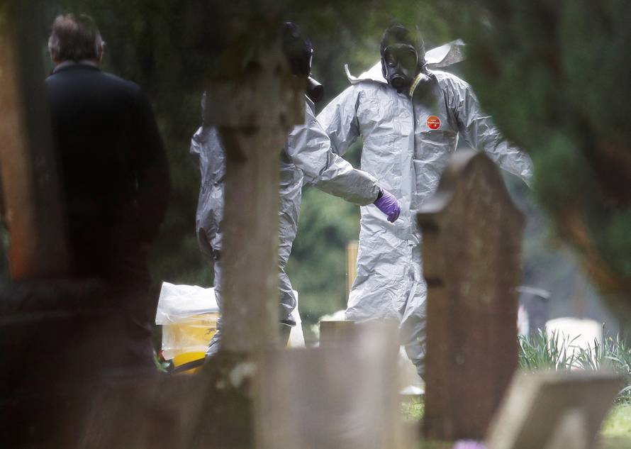 Members of the emergency services help each other to remove their protective suits at the site of the grave of Luidmila Skripal, wife of former Russian inteligence officer Sergei Skripal, at London Road Cemetery in Salisbury