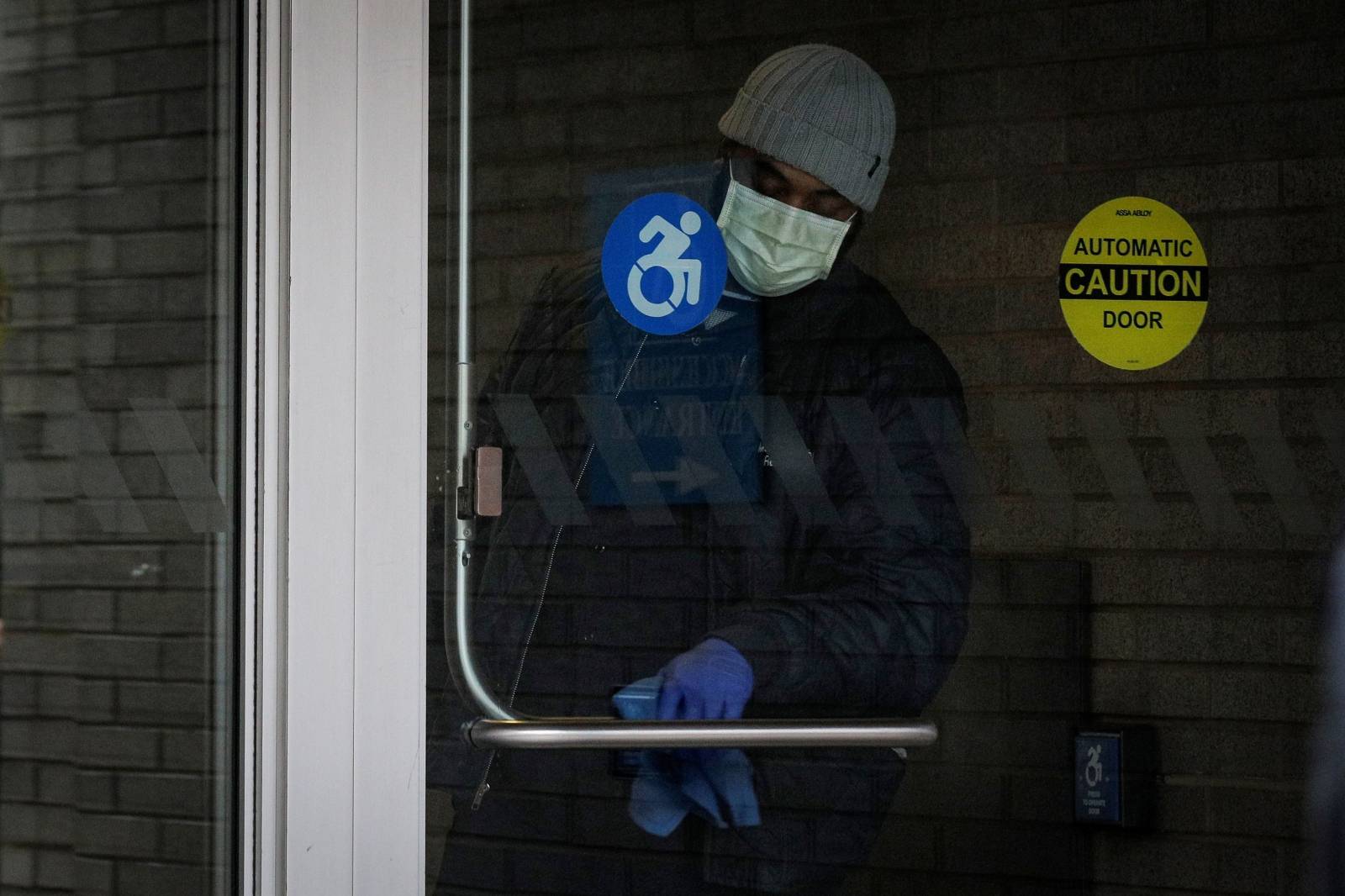 A member of the hospital staff cleans the door at Mount Sinai Hospital, during the outbreak coronavirus disease (COVID-19)  outbreak, in New York