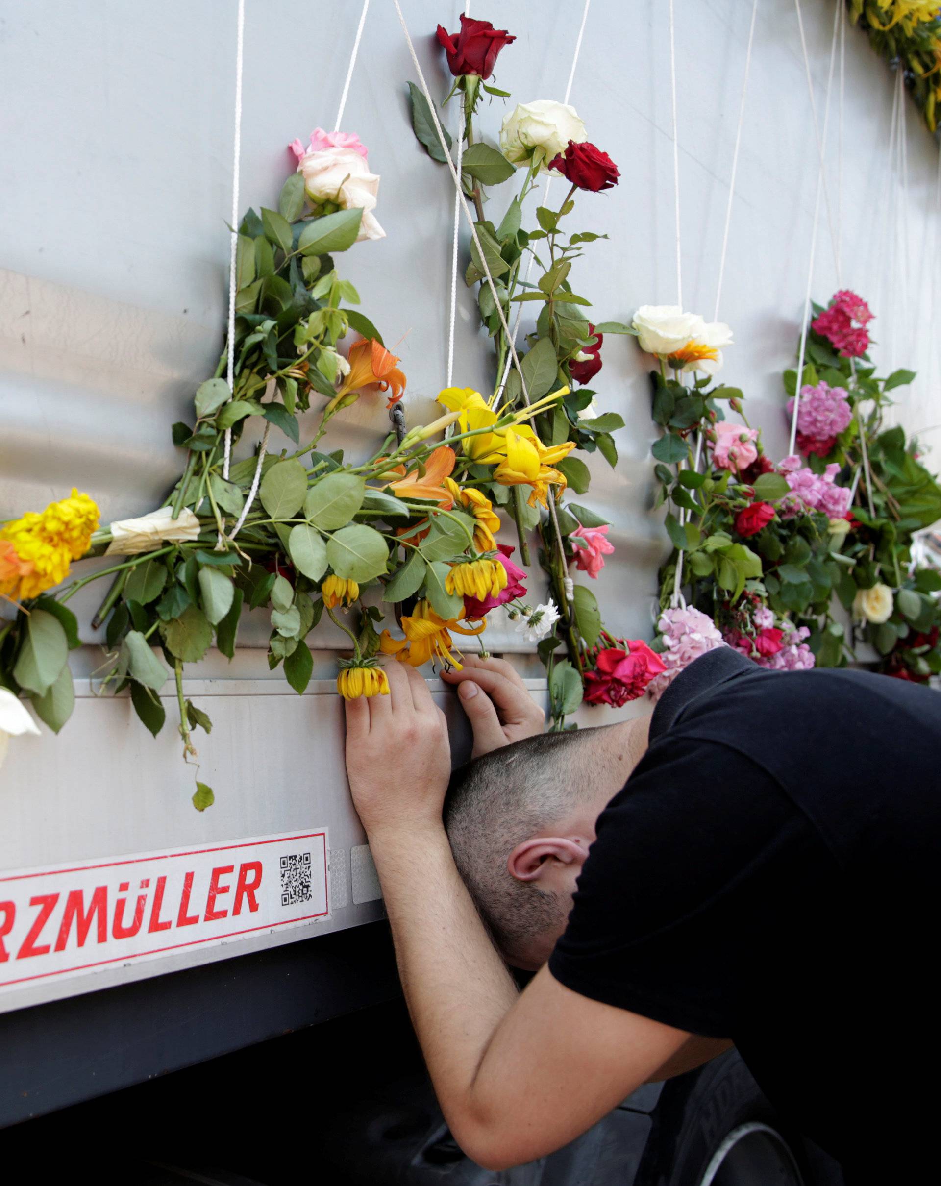 A man reacts near a truck carrying coffins of newly identified victims of the 1995 Srebrenica massacre, in front of the presidential building in Sarajevo