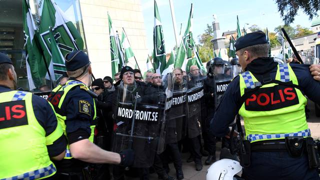 Police officers stop NMR demonstrators from trying to walk along a forbidden street during the Nordic Resistance Movement march in central Gothenburg