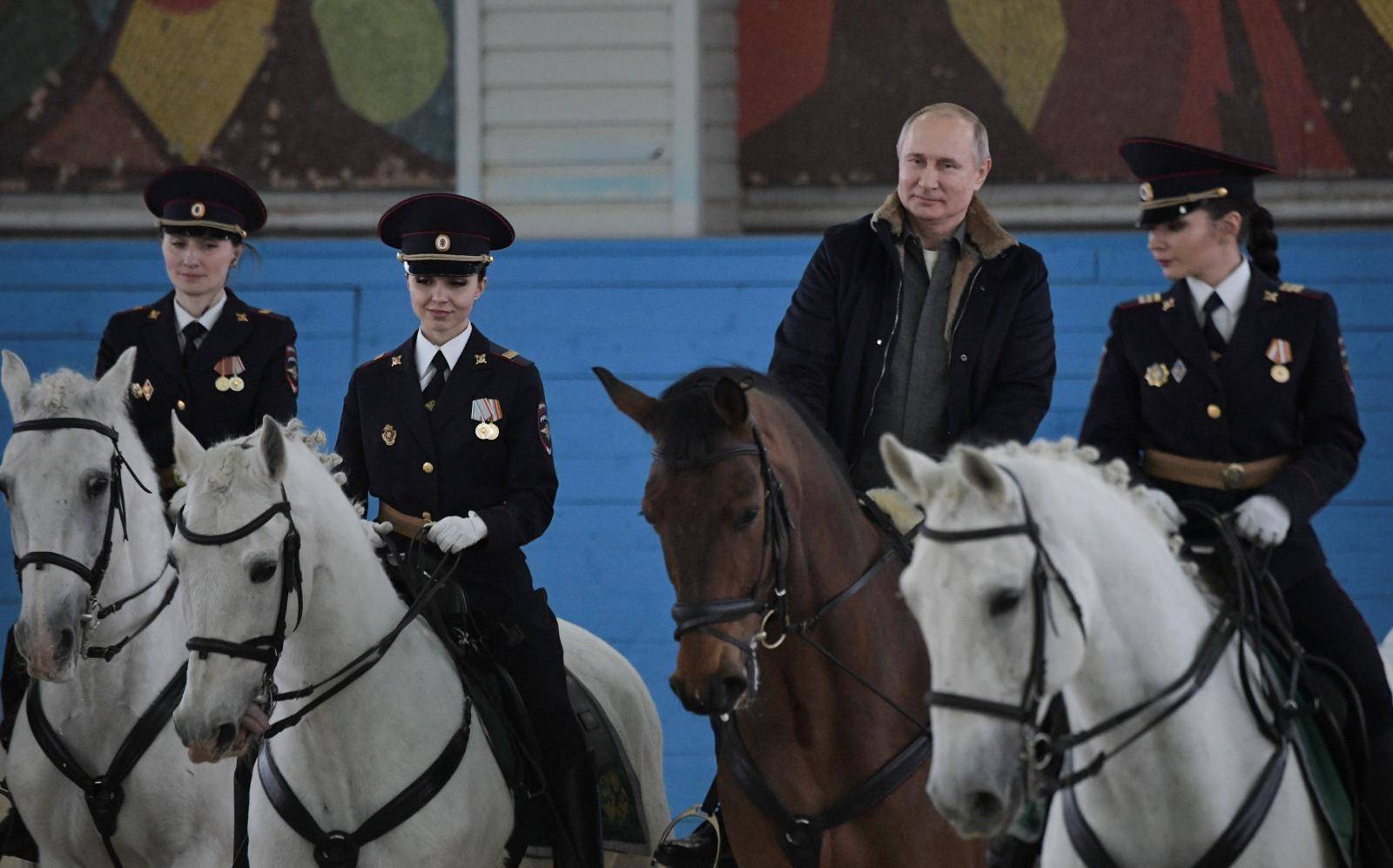 Russian President Putin rides a horse as he meets with female police officers on the eve of International Women's Day in Moscow