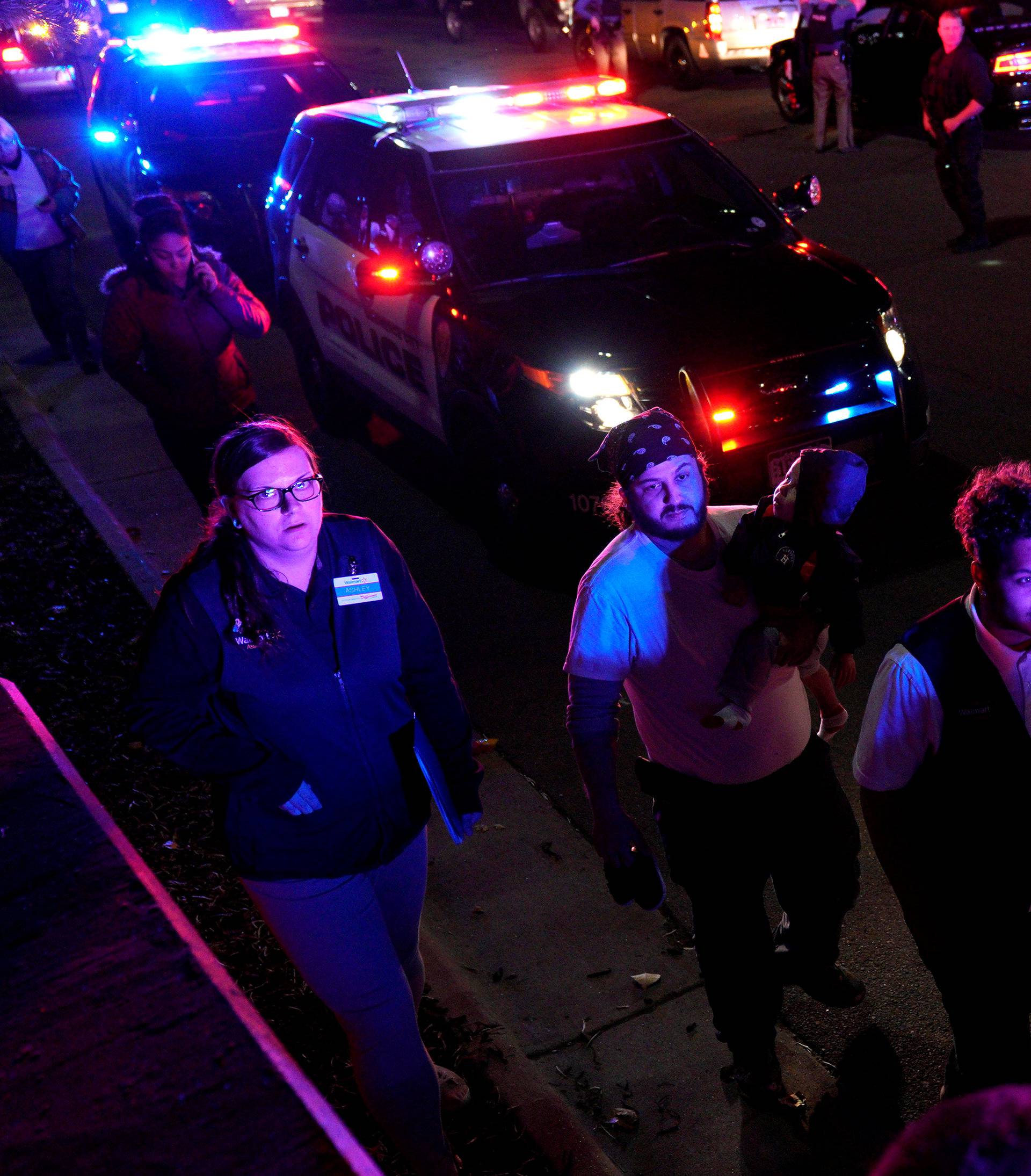 Walmart employees and shoppers leave the scene of a shooting at a Walmart in Thornton