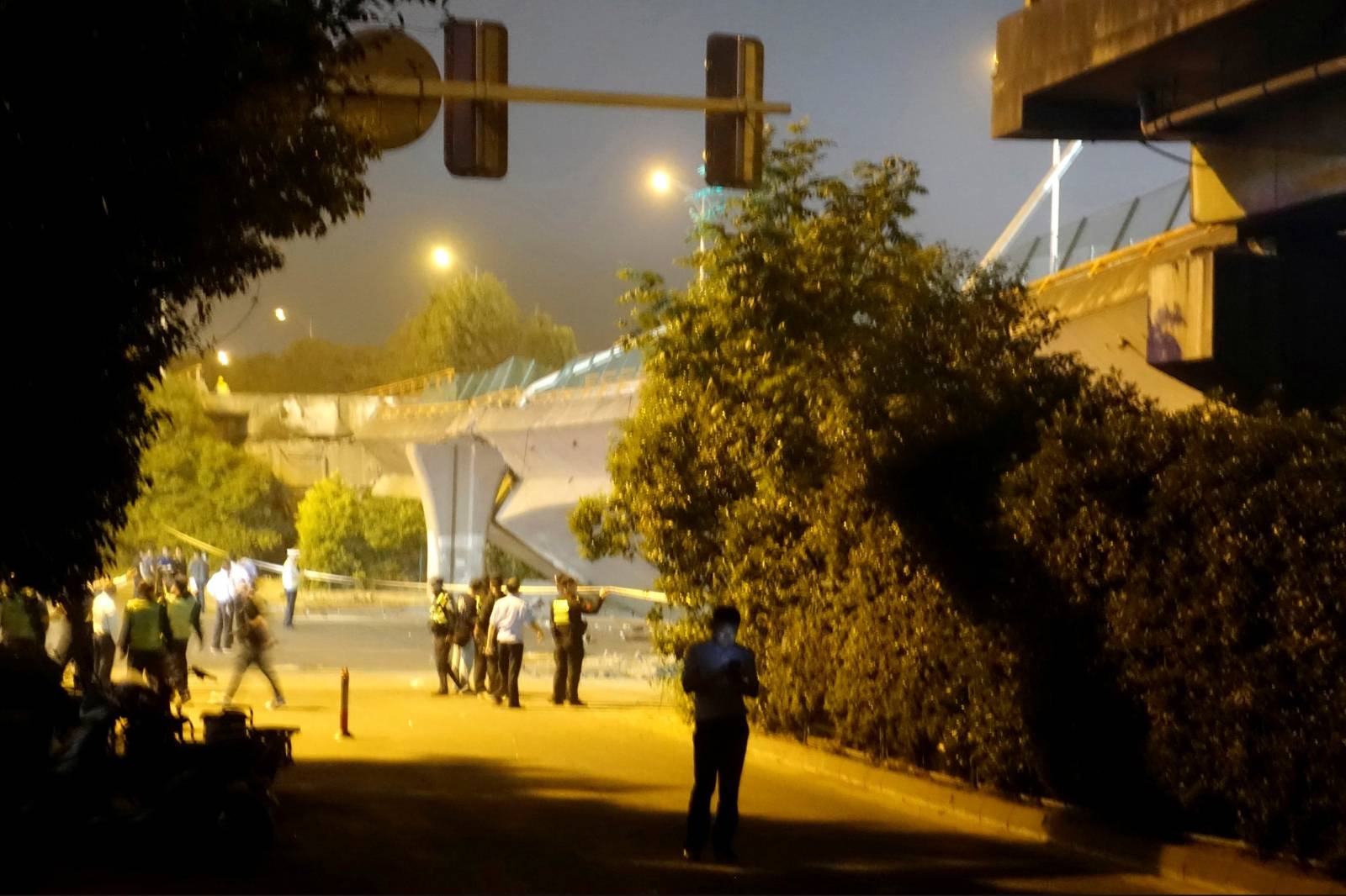 Police and rescue workers are seen next to a collapsed highway overpass in Wuxi, Jiangsu