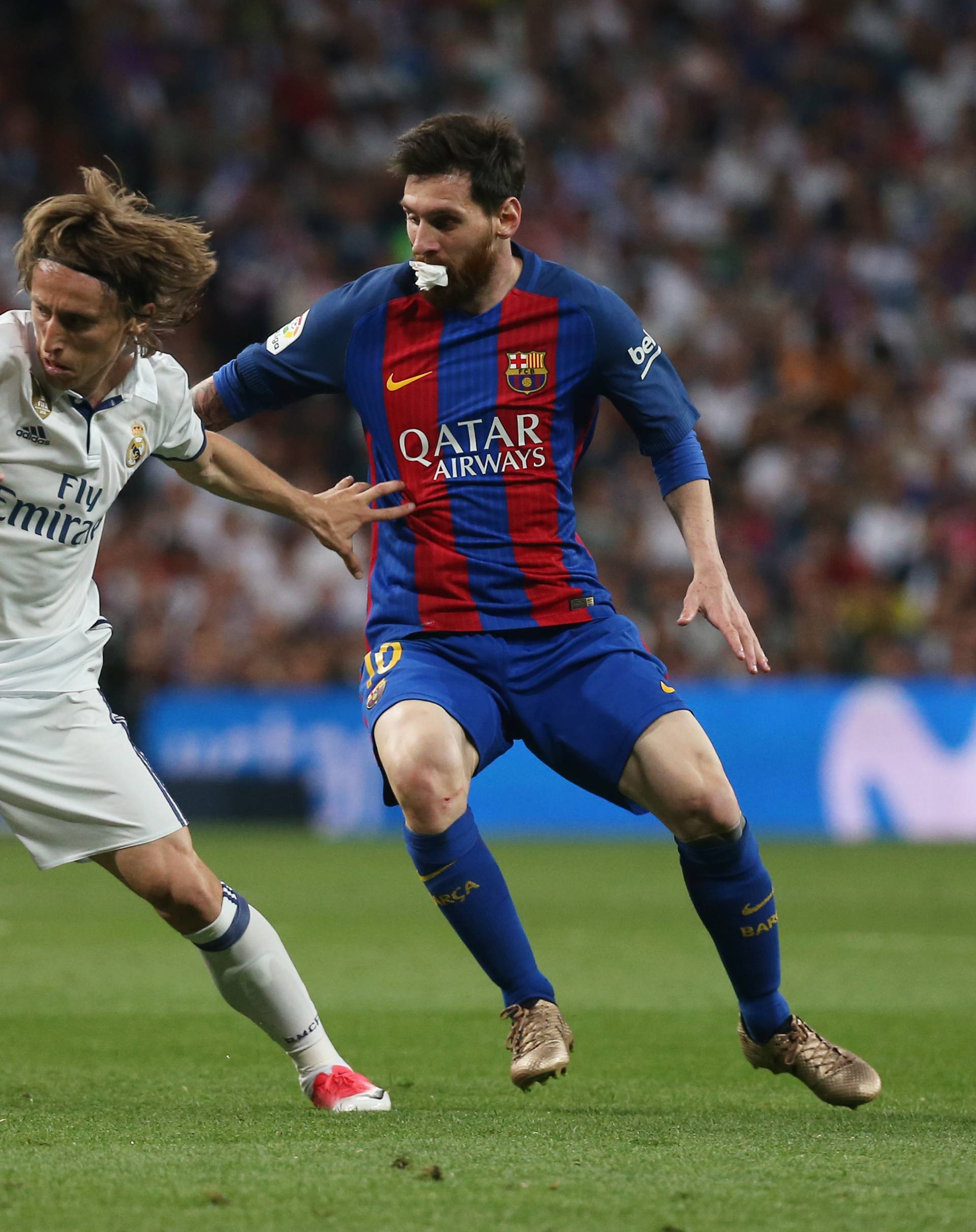 Real Madrid's Luka Modric in action with Barcelona's Lionel Messi