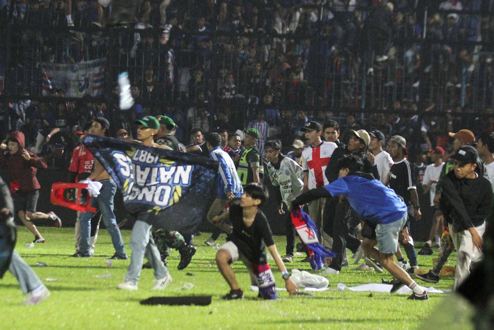 Arema FC supporters enter the field after the team they support lost to Persebaya after the league BRI Liga 1 football match in Malang