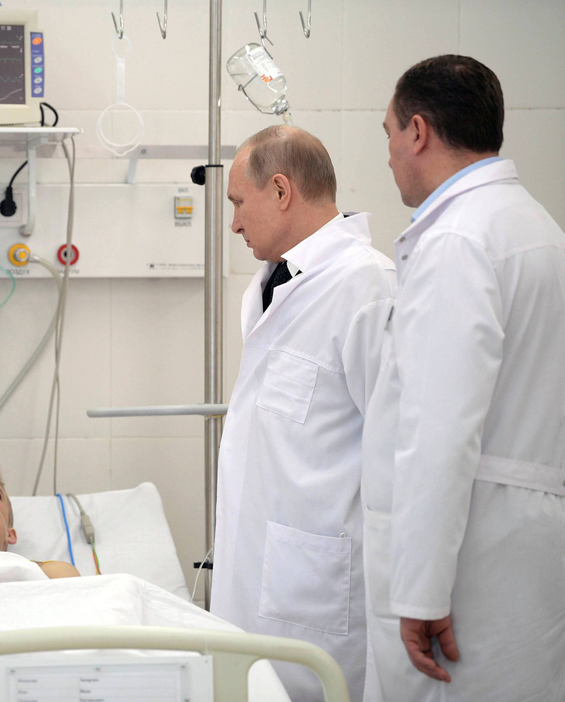 Russian President Vladimir Putin meets with victims injured during a fire in a shopping mall, at a hospital in Kemerovo