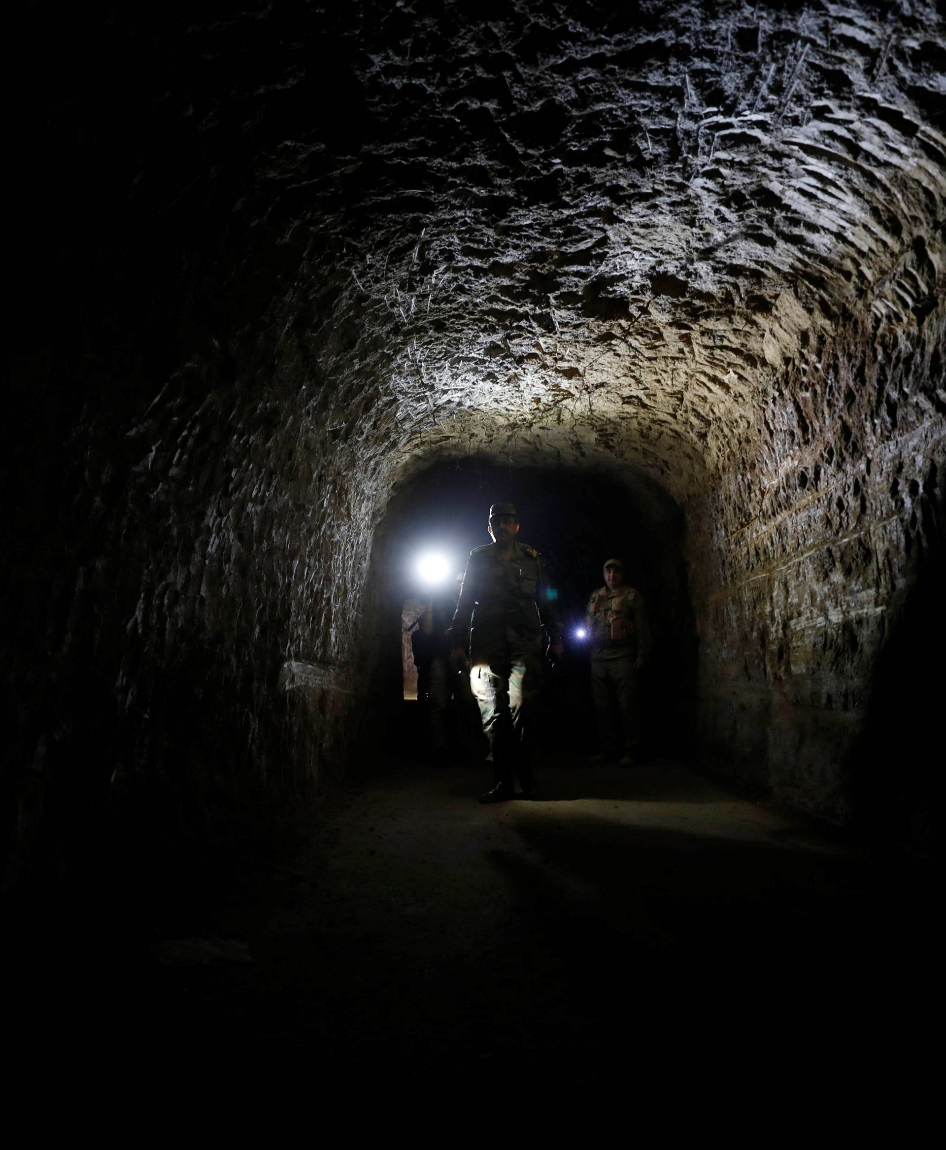 Member of Syrian forces of President Bashar al Assad walks inside a tunnel that was used by rebels in Jobar, eastern Ghouta, in Damascus