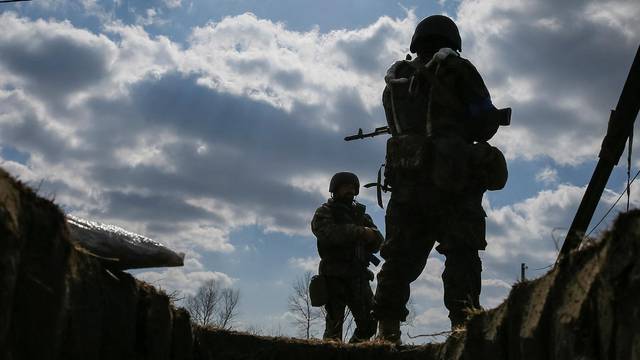 Ukrainian service members stand at a position on the front line in the north Kyiv region