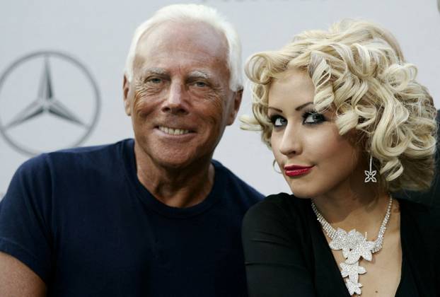 FILE PHOTO: Italian designer Giorgio Armani (L) and pop star Christina Aguilera take part in a press conference ..