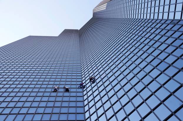 French Spiderman Alain Robert and climbers Martin Banot, Alexis Landot and Leo Urban climb a skyscraper in La Defense near Paris