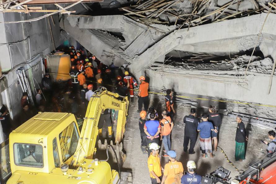 Search and rescue officers search for victims in the rubble of a collapsed building at an Islamic boarding school in Sidoarjo
