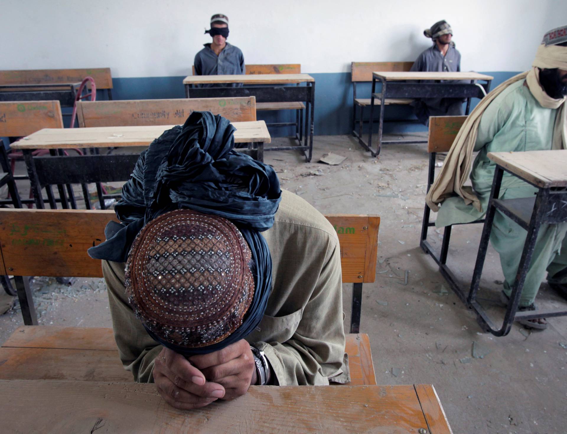 FILE PHOTO: A group of men detained for suspected Taliban activities are held for questioning at a schoolhouse in the village of Kuhak