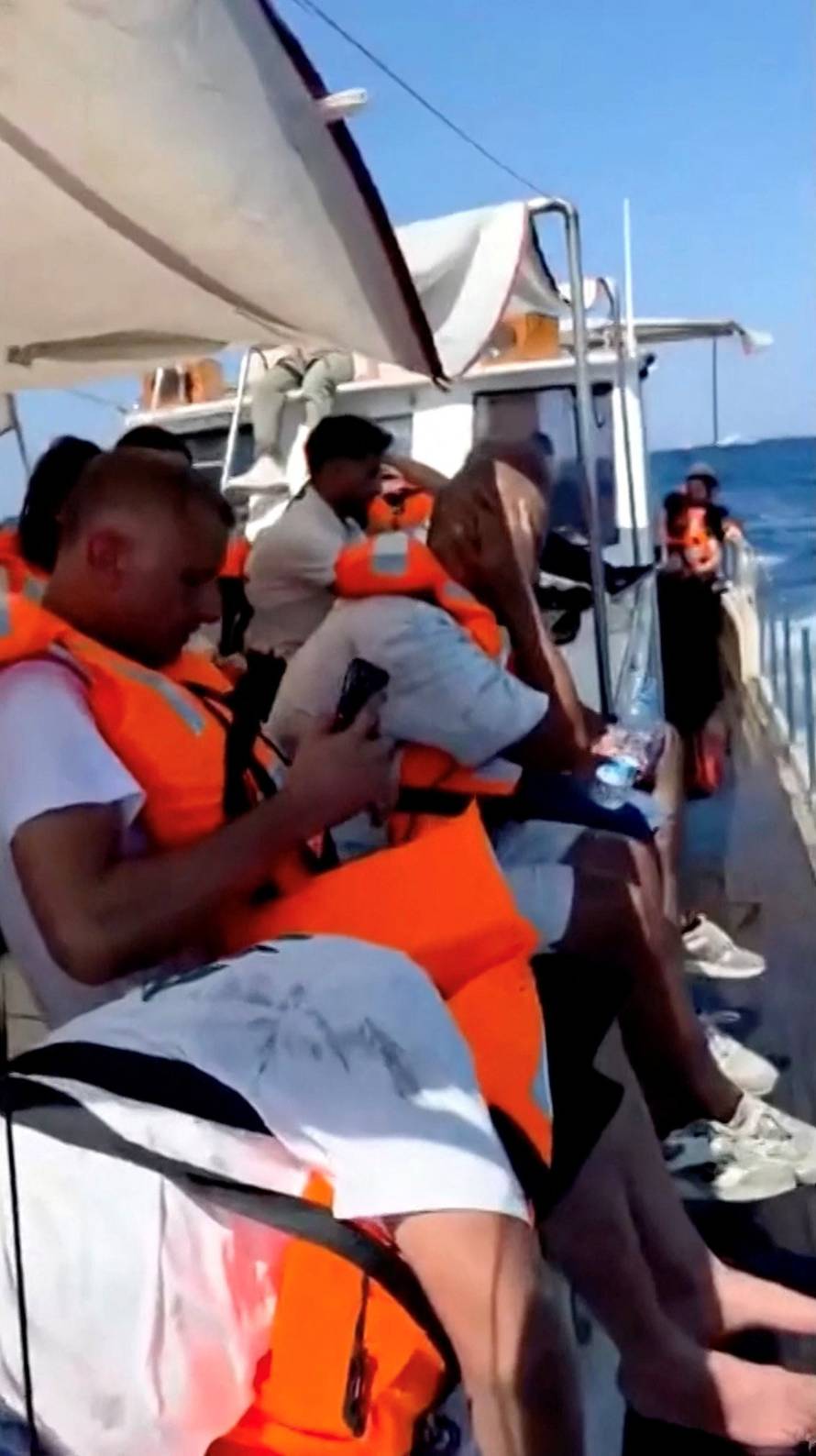 Passengers head to the shore on a boat after being rescued from a vessel that capsized off the coast of Northern Cyprus
