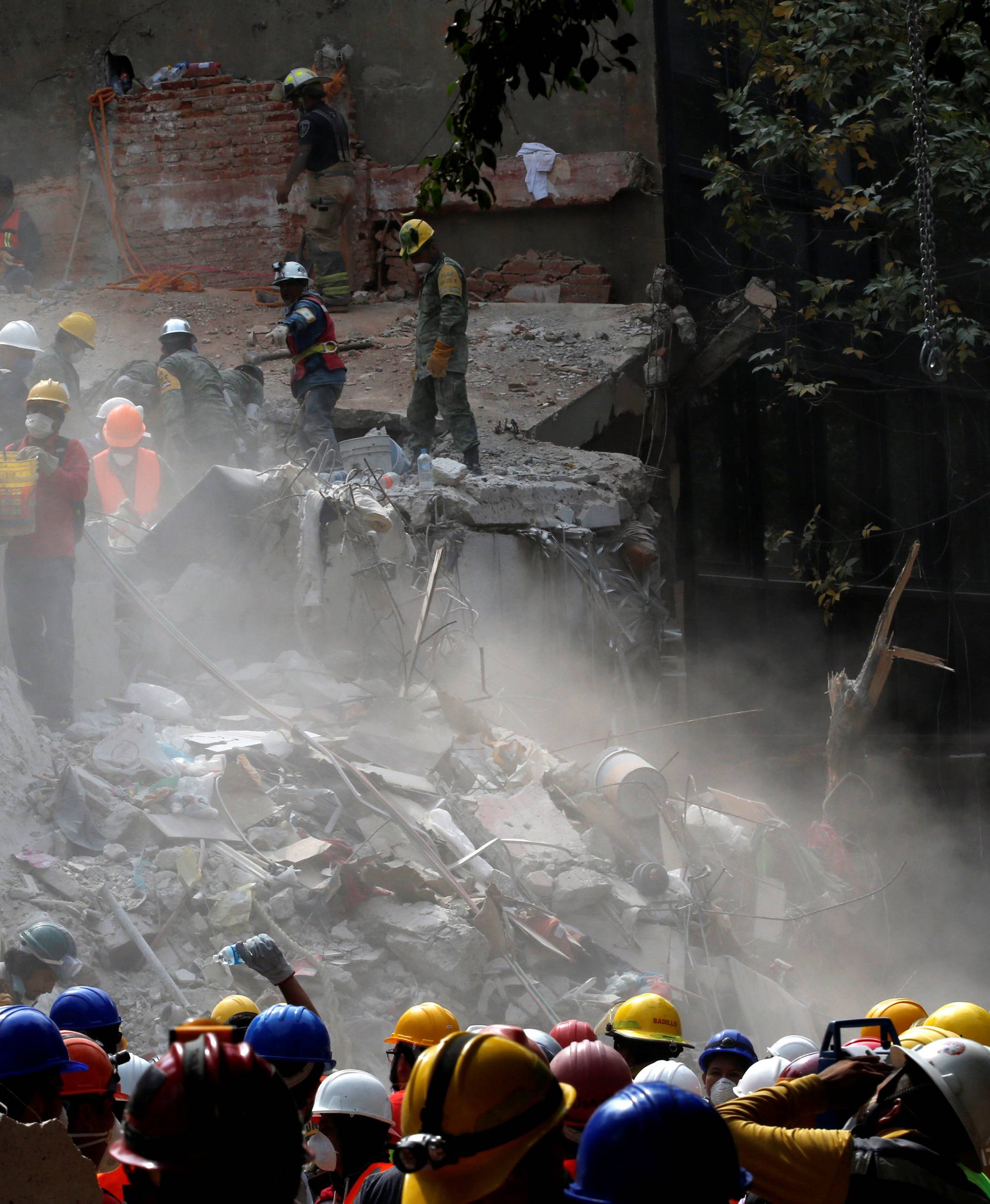 Members of Israeli and Mexican rescue teams and volunteers search for survivors in the rubble of a collapsed building after an earthquake in Mexico City