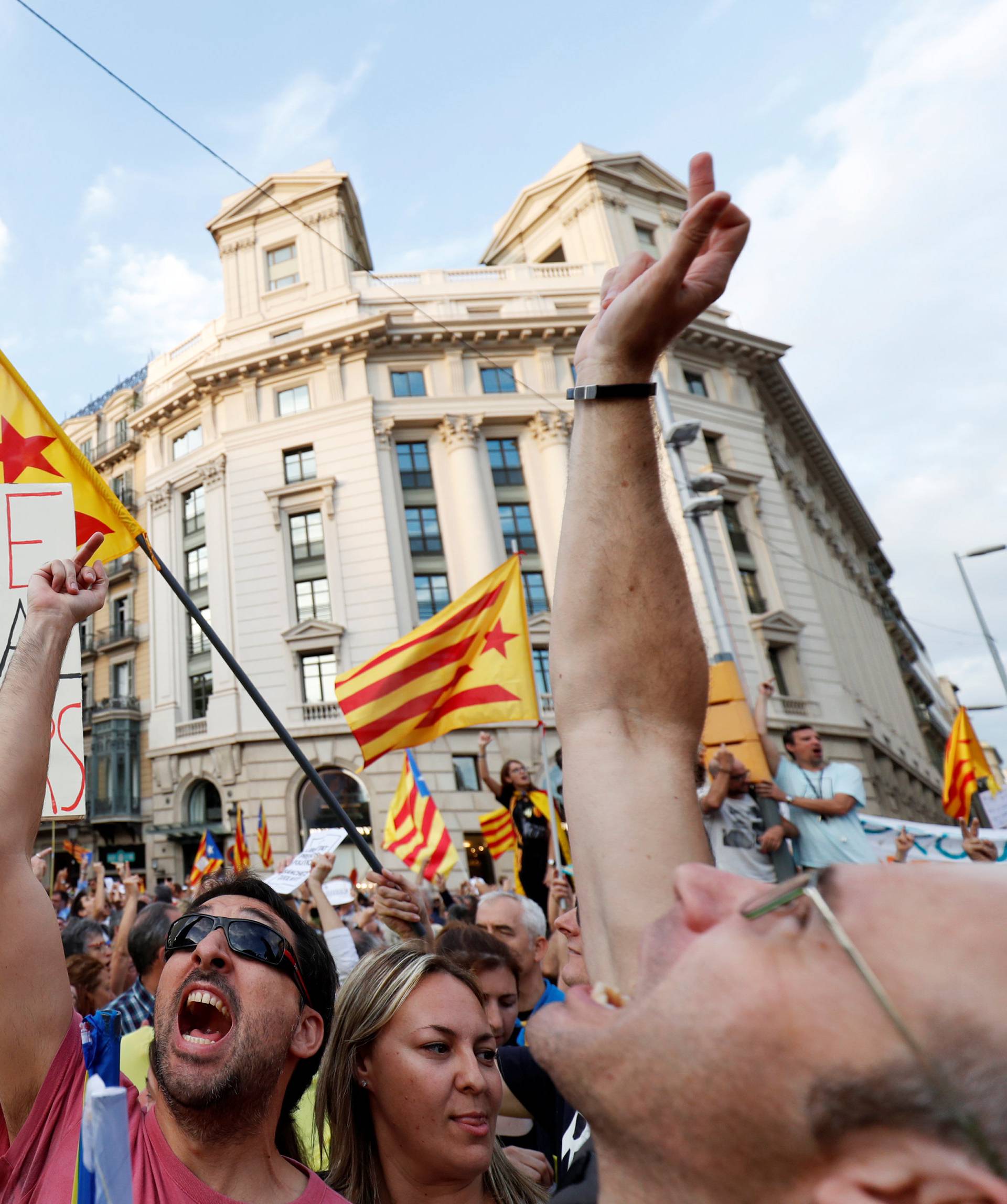 Protesters react to a police helicopter flying overhead during a demonstration organised by Catalan pro-independence movements ANC (Catalan National Assembly) and Omnium Cutural, following the imprisonment of their two leaders, in