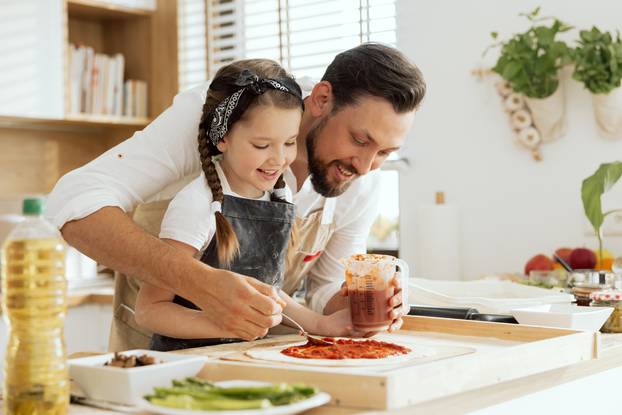 Adorable,Young,Daughter,With,Lovelu,Father,In,Aprons,Applying,Kutchup