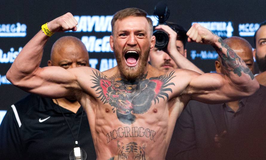 UFC lightweight champion Conor McGregor of Ireland poses on the scale during his official weigh-in at T-Mobile Arena in Las Vegas