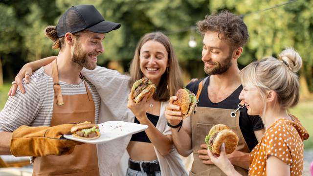 Young,People,Enjoy,Yummy,Burgers,,Made,On,A,Grill,At