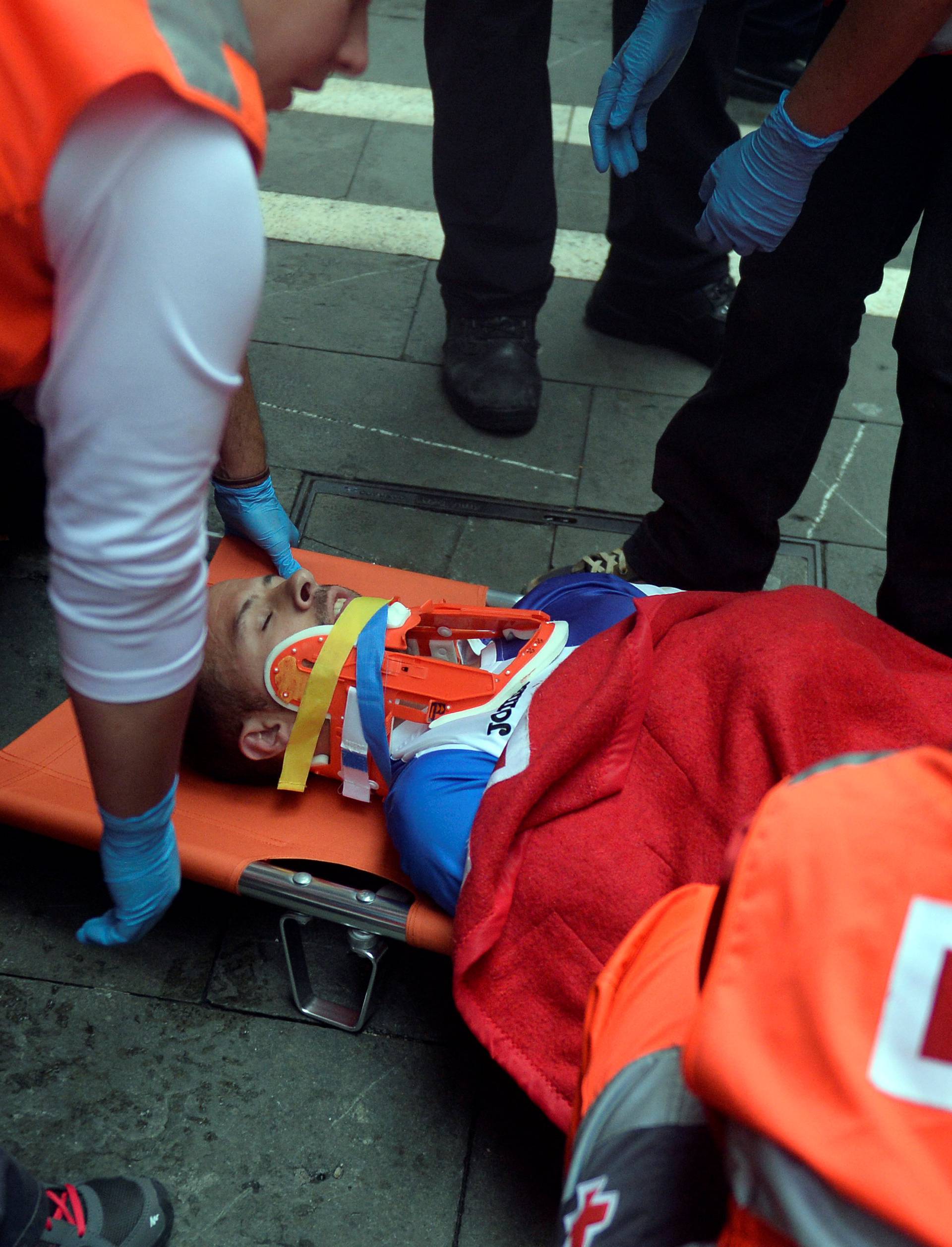 An injured runner is loaded onto a stretcher following the fourth running of the bulls at the San Fermin festival in Pamplona