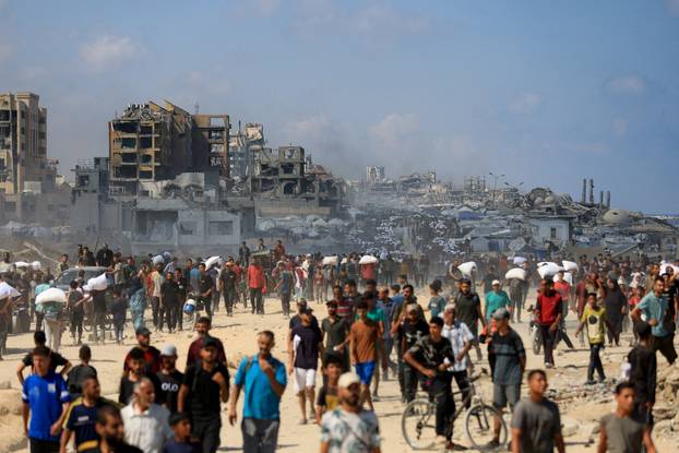 Palestinians gather to receive aid supplies amid a hunger crisis, in Beit Lahia