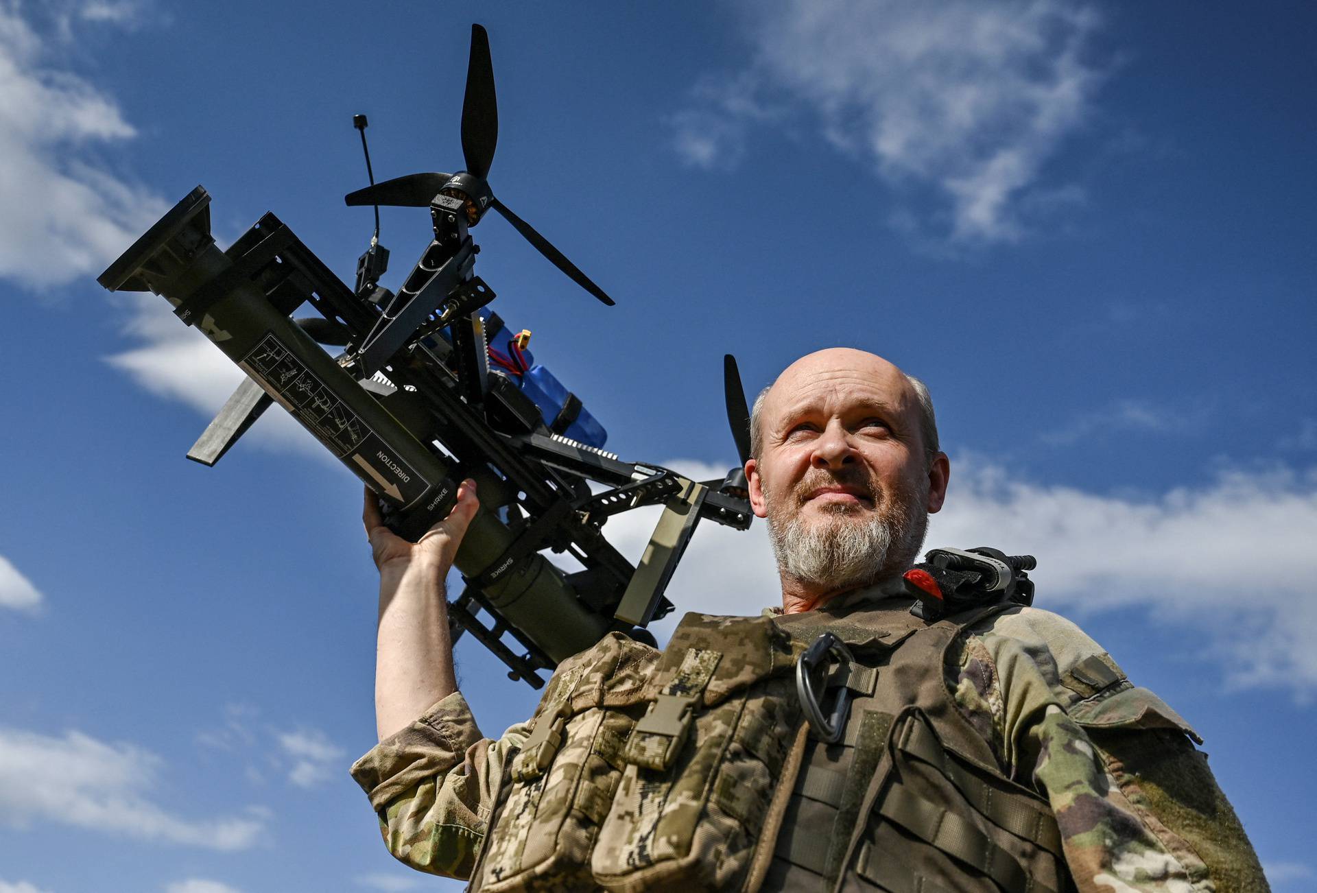 Ukrainian serviceman carries an FPV drone with an attached portable grenade launcher after a test fly at a position near a frontline in the Zaporizhzhia region