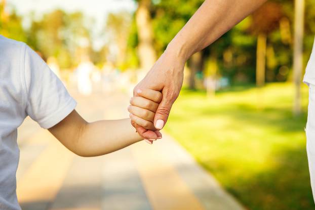 Cropped,Close,Up,Of,A,Boy,And,Grandmother,Holding,Hands.