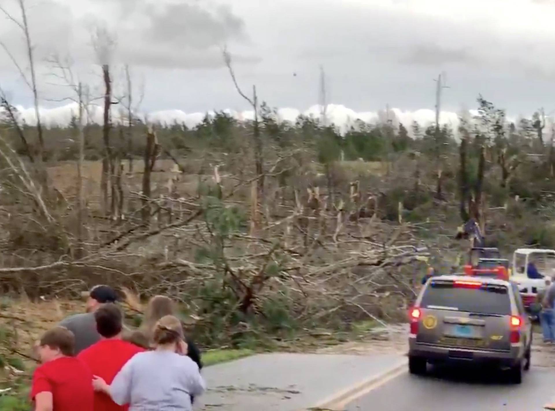 People look on as debris is cleared along a road following a tornado in Beauregard, Alabama, U.S. in this March 3, 2019 still image obtained from social media video