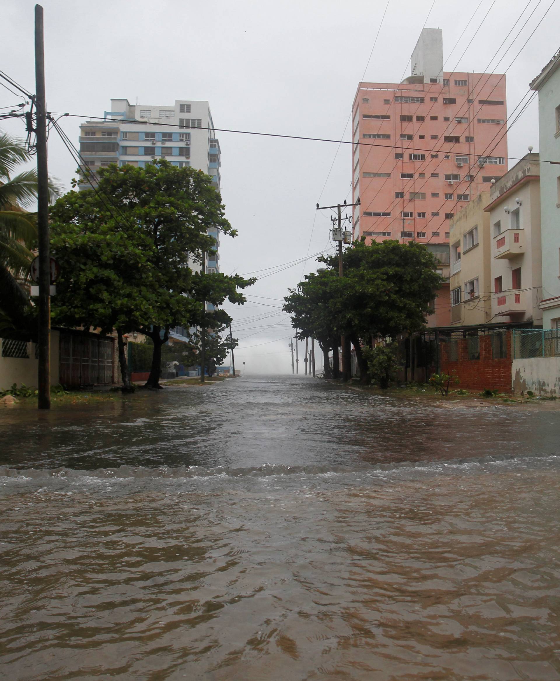 People look at the flooded street from a balcony as Hurricane Irma turns toward the Florida Keys on Saturday, in Havana