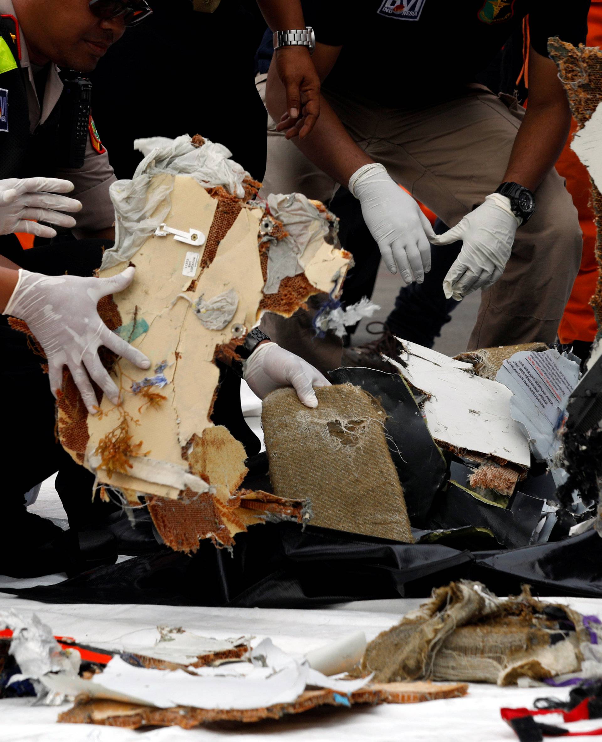 Rescue workers lay out newly recovered debris of Lion Air flight JT610 at Tanjung Priok port in Jakarta