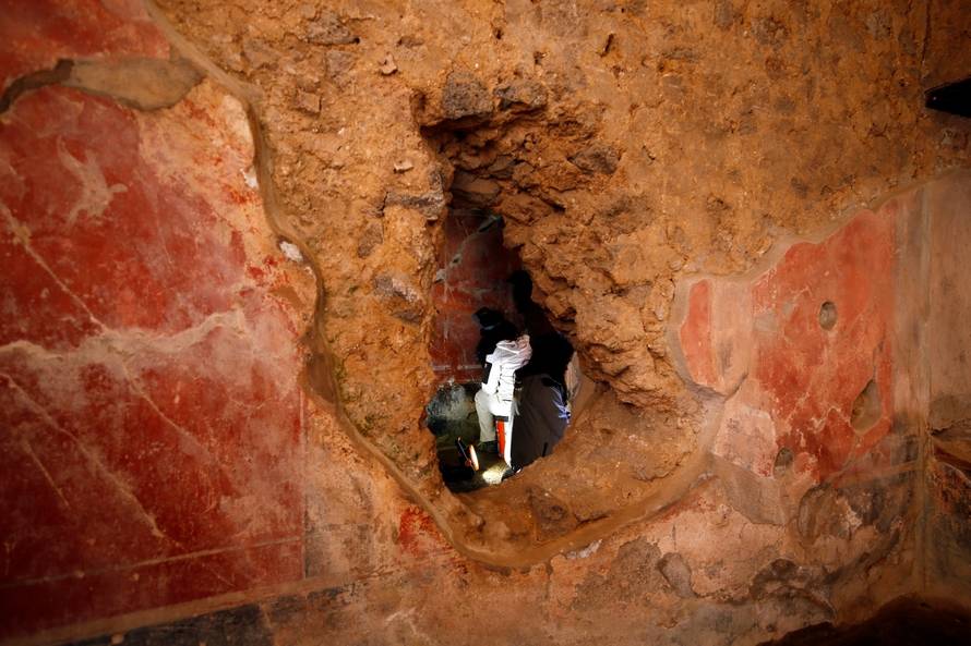 An archaelogist works on a fresco in the House of Lovers "Casa degli Amanti\
